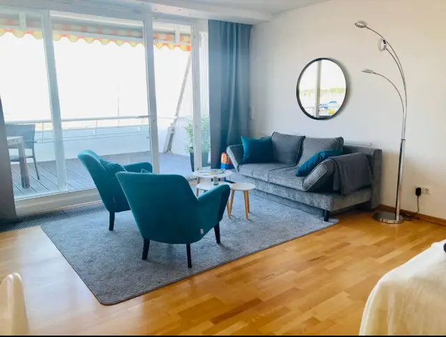 Wohnzimmer mit Sofa und Sesseln, Panorama am Strand